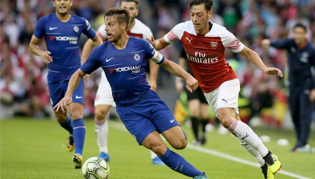 Hai cầu thủ Chelsea và Arsenal tranh bóng trên sân cỏ xanh mướt