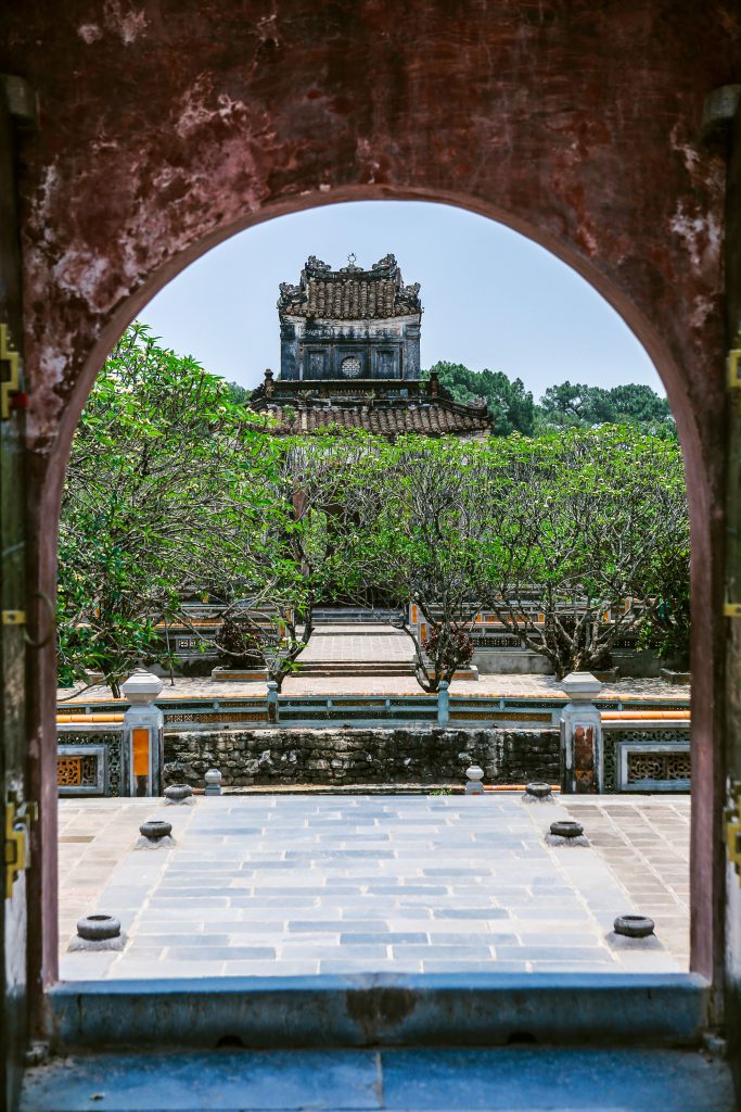 Courtyard view of a historic Hue monument framed by an archway