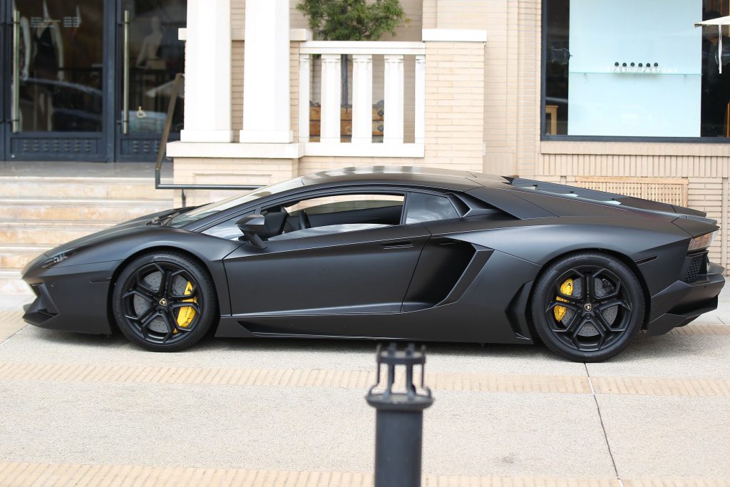 Siêu xe Lamborghini Aventador màu đen nhám đầy quyền lực đậu bên lề đường.