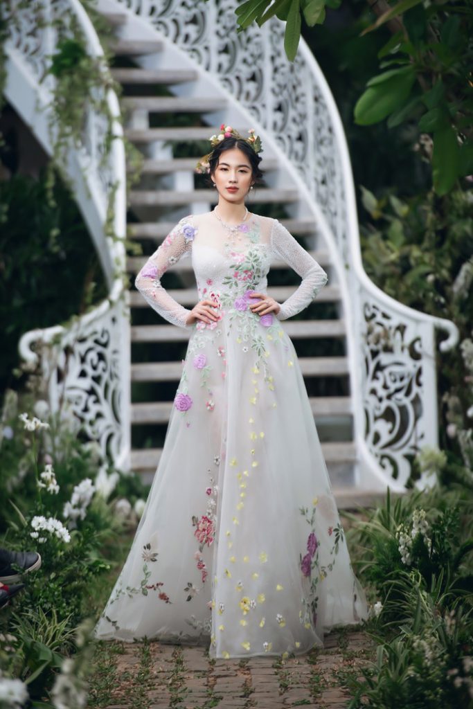 Thiết kế áo dài phom dáng cổ điển kết hợp với phụ kiện mấn đội đầu và hoa văn thêu tinh xảo mang đậm nét văn hóa.