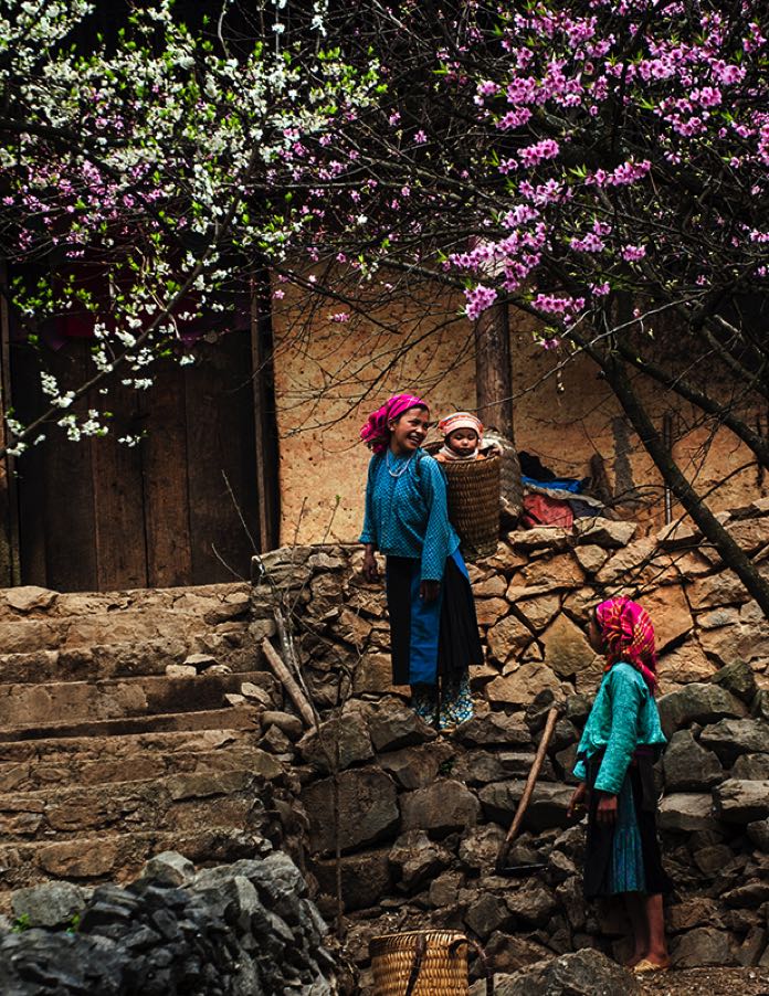 Children playing in a courtyard of a stone house in a highland village