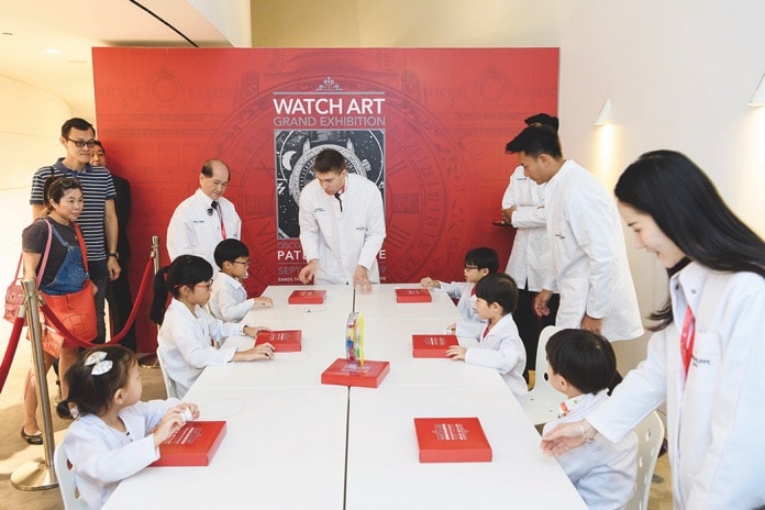 Khách tham quan và trẻ em tại buổi triển lãm nghệ thuật chế tác đồng hồ của Patek Philippe.