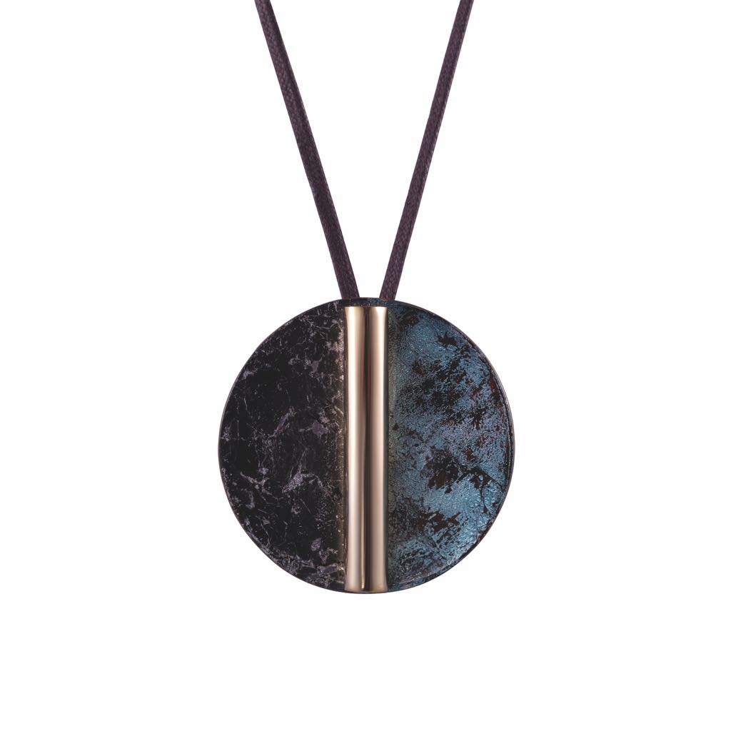 Sợi dây chuyền nổi bật với mặt tròn lớn kết hợp giữa chất liệu kim loại và họa tiết đá màu xanh đen