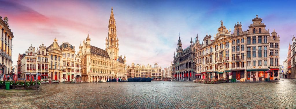 Grand Place in Brussels features ornate buildings and a cobblestone square under a colorful sky