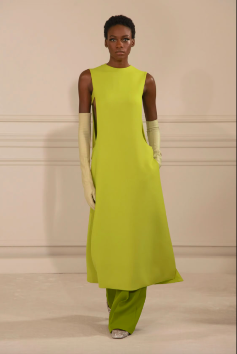 Người mẫu trình diễn váy xanh lá cây và găng tay dài thời trang cao cấp