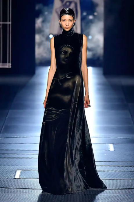 Người mẫu trình diễn váy đen dài thêu hình mặt người trong buổi giới thiệu bộ sưu tập thời trang cao cấp