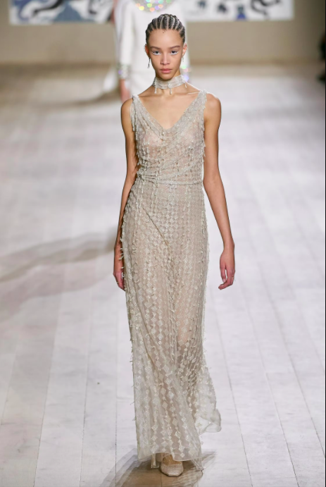 Người mẫu trình diễn váy dạ hội lụa trắng tinh tế trên sàn diễn thời trang