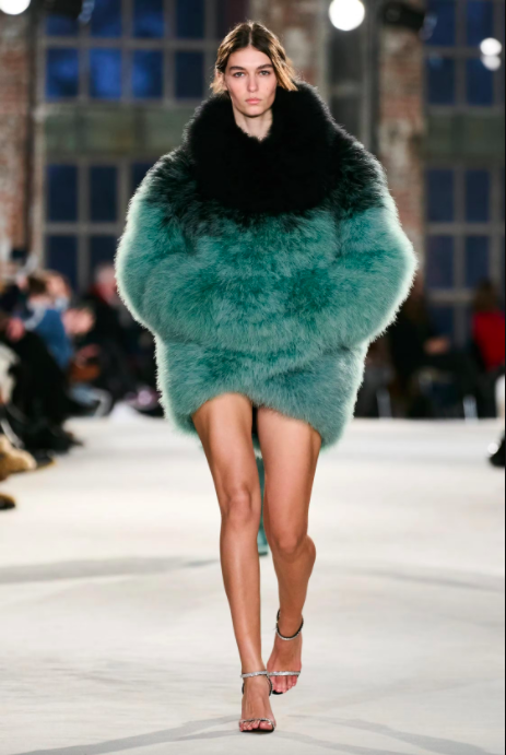 Người mẫu trình diễn áo lông xanh lục nổi bật trên sàn diễn thời trang