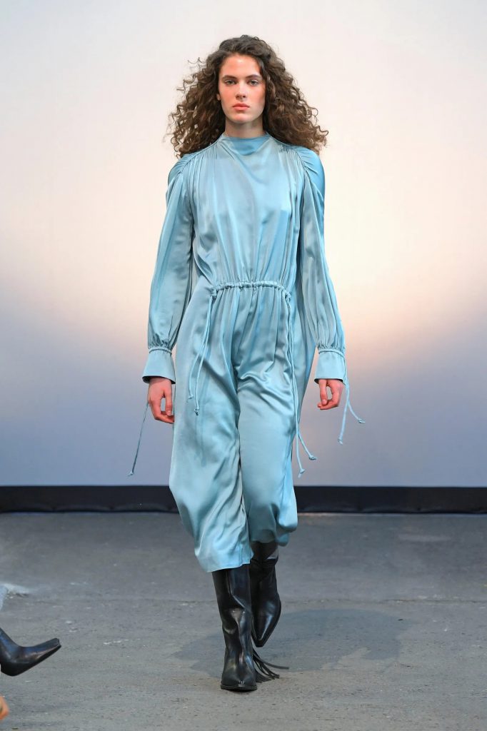 Người mẫu trình diễn bộ jumpsuit xanh da trời lụa trên sàn catwalk