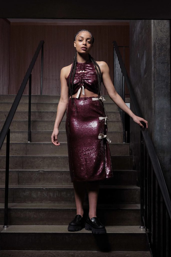Người mẫu diện trang phục màu đỏ burgundy trên cầu thang