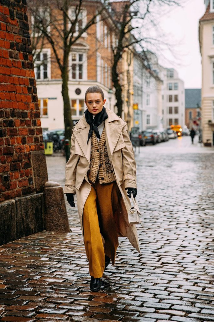 Người mẫu diện áo khoác dài và quần màu vàng đi trên phố Copenhagen
