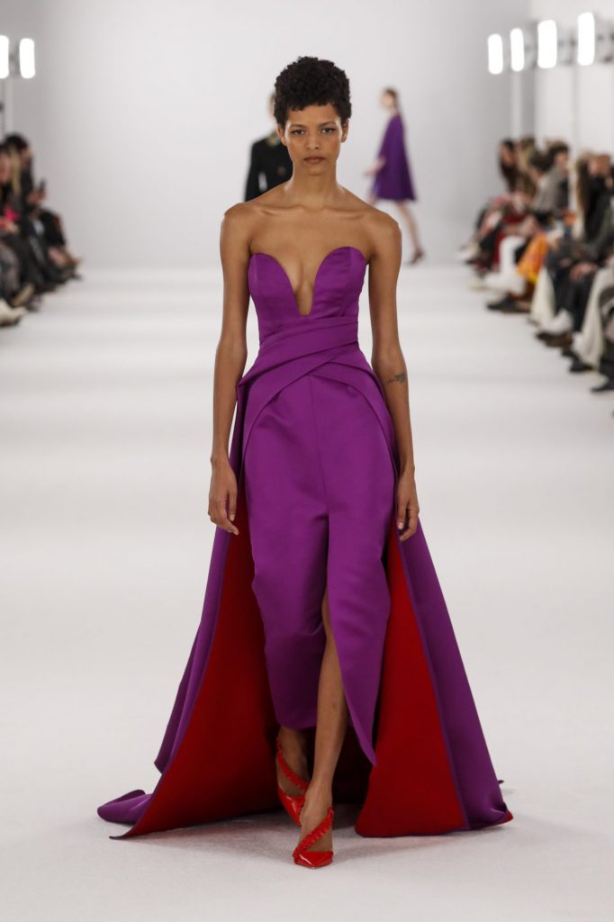 Người mẫu trình diễn váy tím và đỏ trên sàn catwalk thời trang