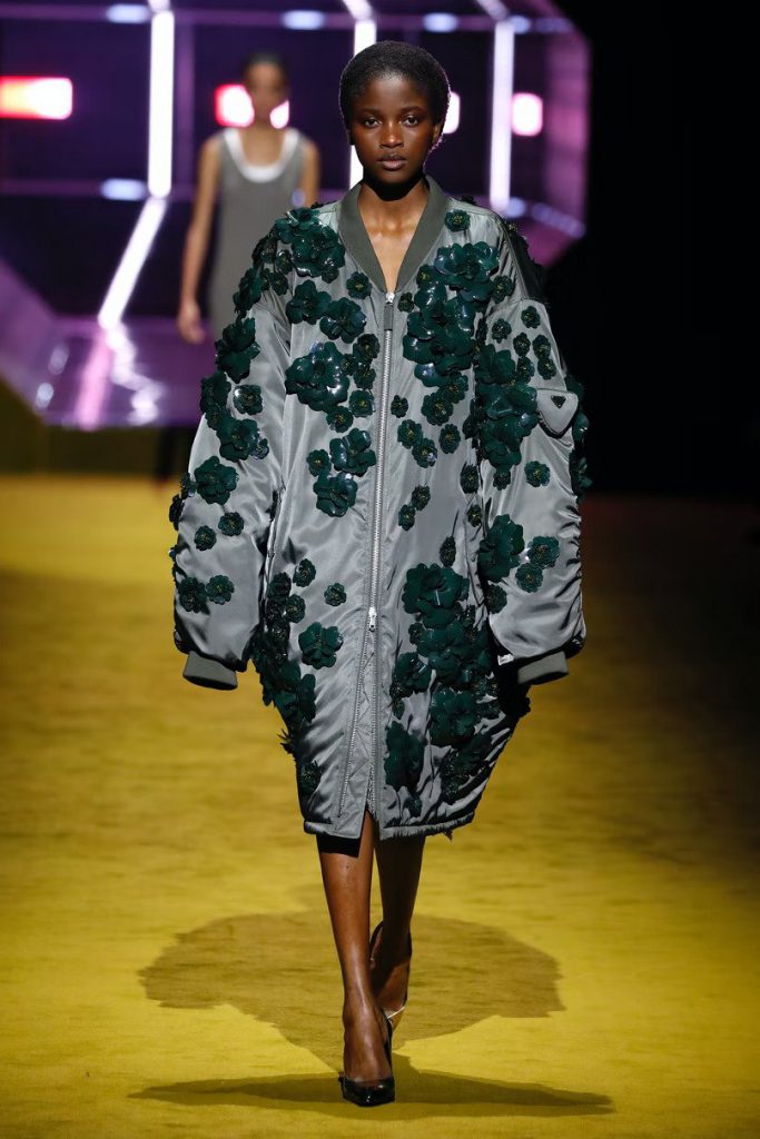 Người mẫu trình diễn áo khoác trang trí hoa trên sàn diễn Prada