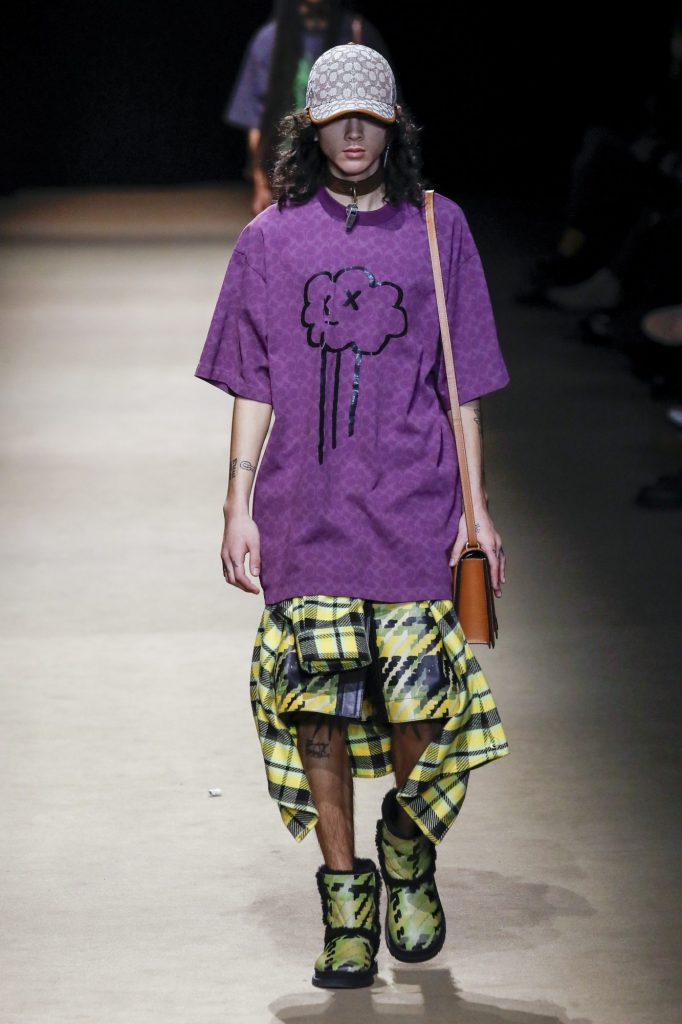 Người mẫu nam trình diễn trang phục màu tím than và kẻ sọc vàng trên sàn diễn