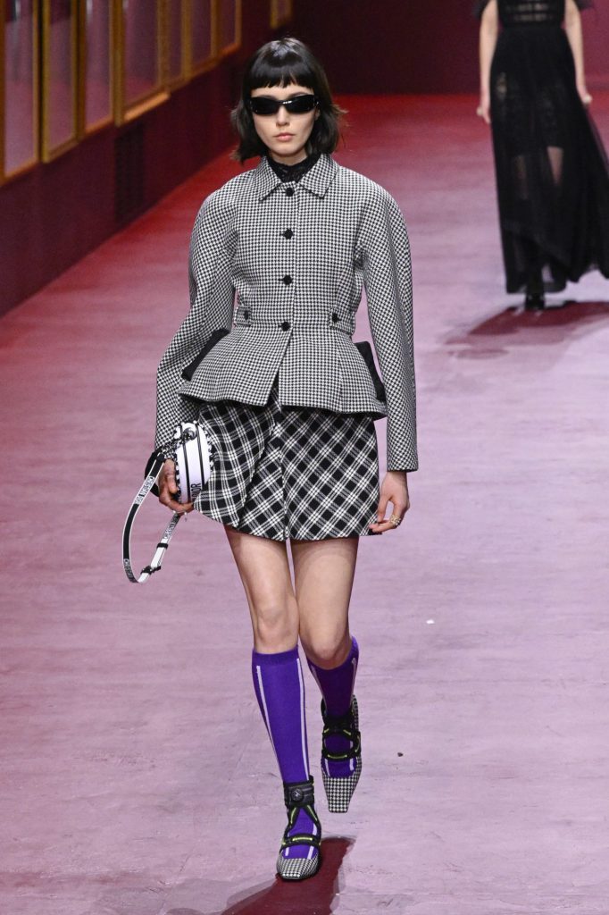 Người mẫu trình diễn trang phục kẻ sọc đen trắng cùng tất tím trên sàn diễn thời trang