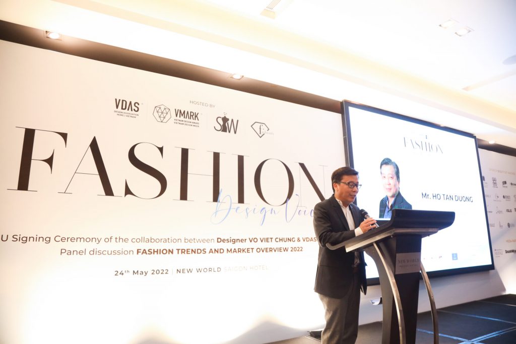 Người đàn ông mặc vest đang phát biểu tại buổi ra mắt dự án thời trang