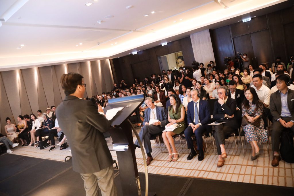 Người thuyết trình trước đám đông khán giả trong một hội trường lớn