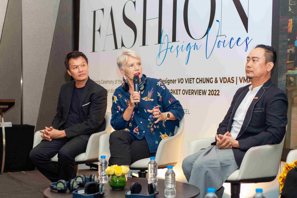 Ba người tham gia buổi thảo luận về thời trang với phông nền có chữ "FASHION Design Voices"