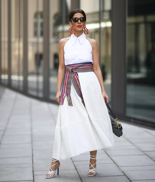 Cô gái mặc váy trắng kín đáo kết hợp áo và thắt lưng sọc nổi bật