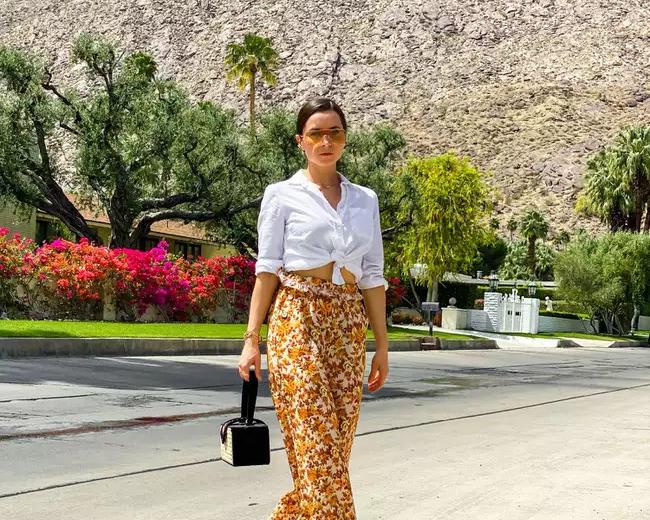 Cô gái mặc áo sơ mi trắng và quần họa tiết hoa nổi bật trên phố