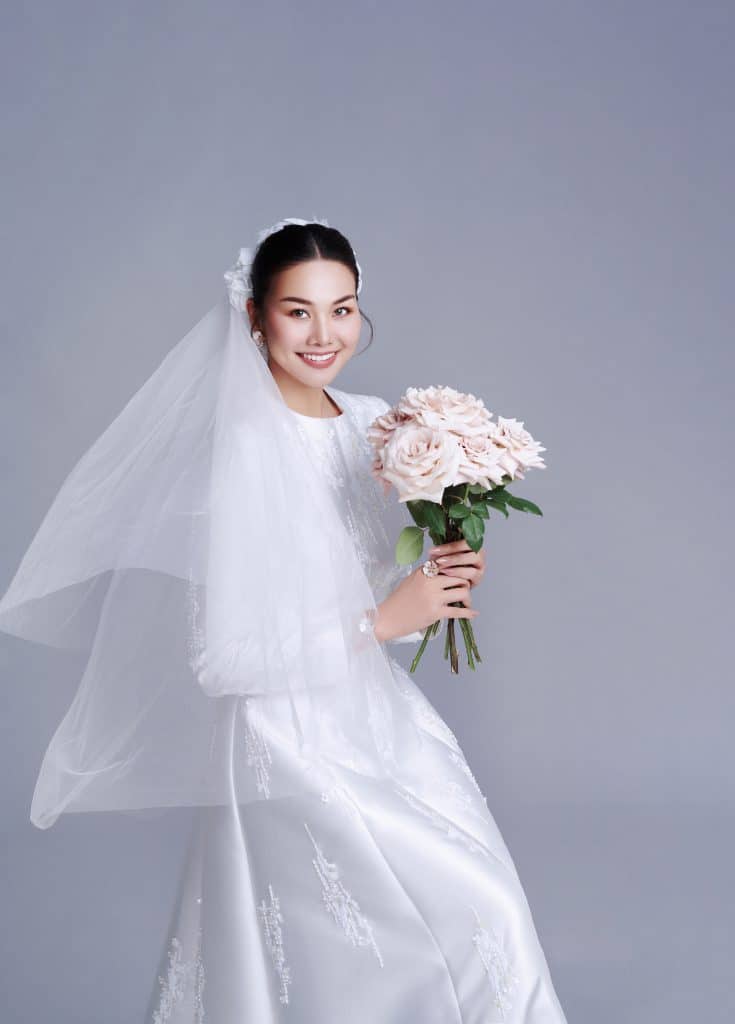 Thanh Hằng xinh đẹp trong trang phục cô dâu cầm bó hoa hồng phấn