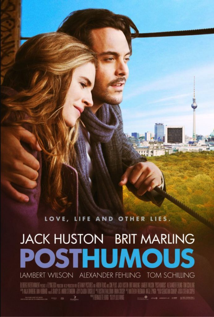 A couple embraces while looking toward a city skyline with a tall tower