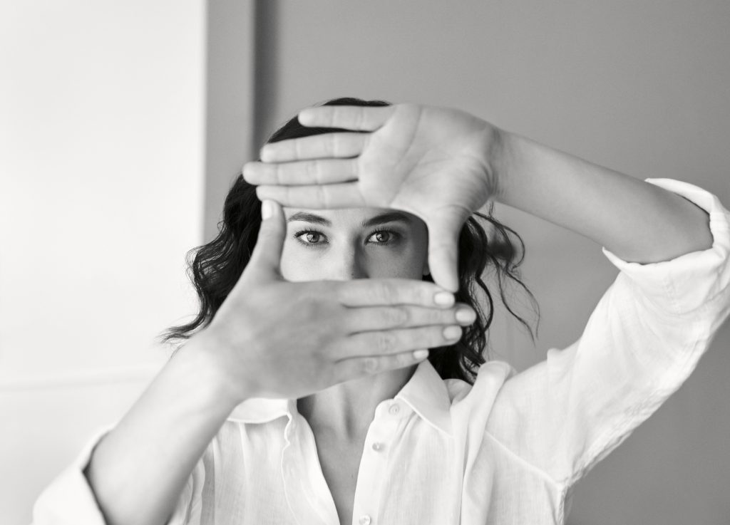 Cô gái tạo khung hình bằng hai tay trước mặt nhìn thẳng vào ống kính