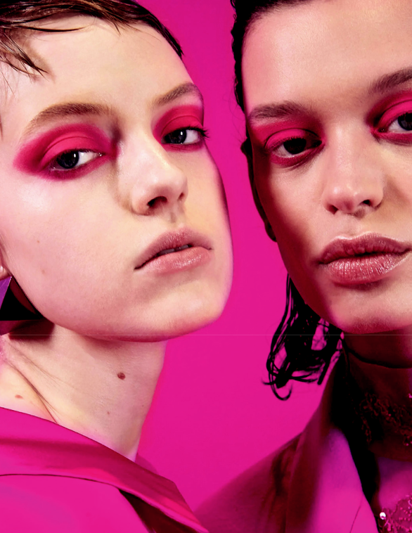 Hai người mẫu với trang điểm mắt màu hồng rực rỡ trên nền hồng đậm