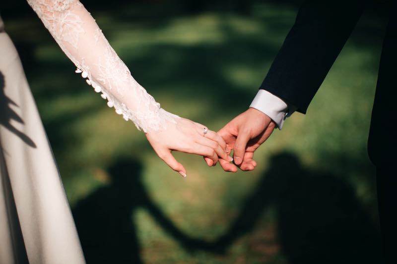 Cô dâu chú rể nắm tay nhau tình cảm trong ngày cưới lãng mạn