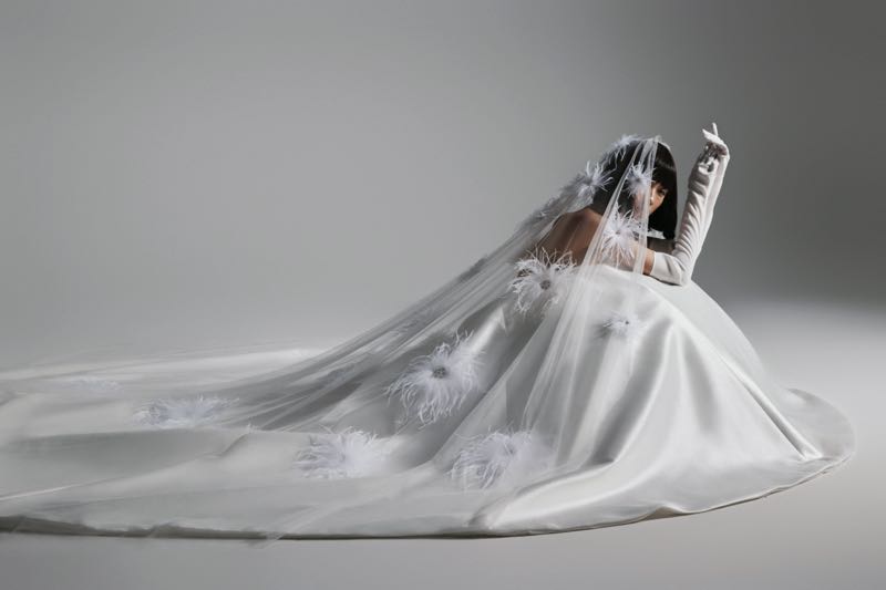 Cô dâu khoác chiếc váy cưới trắng tinh khôi với khăn voan lông vũ mềm mại