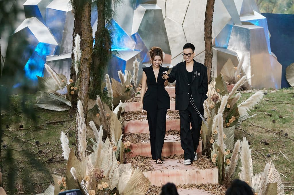 Nhà thiết kế và người mẫu sải bước trên sàn diễn ngoài trời với thiết kế đen trang nhã