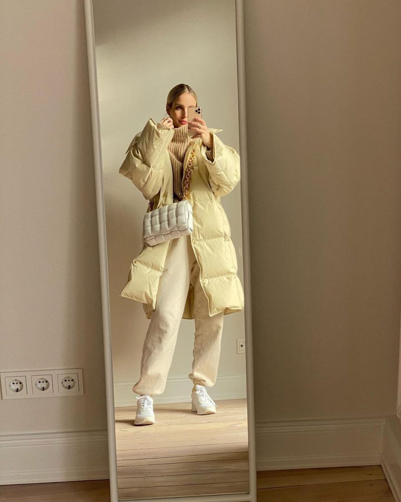 Cô gái diện áo phao dáng rộng màu kem cùng quần thể thao và giày trắng