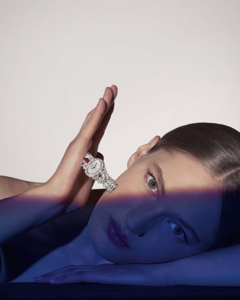 Người mẫu nằm nghiêng đeo chiếc đồng hồ kim cương trên tay