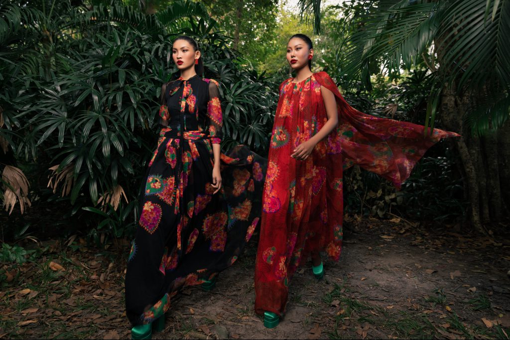 Hai người mẫu diện trang phục hoa văn nổi bật giữa khung cảnh thiên nhiên xanh mát