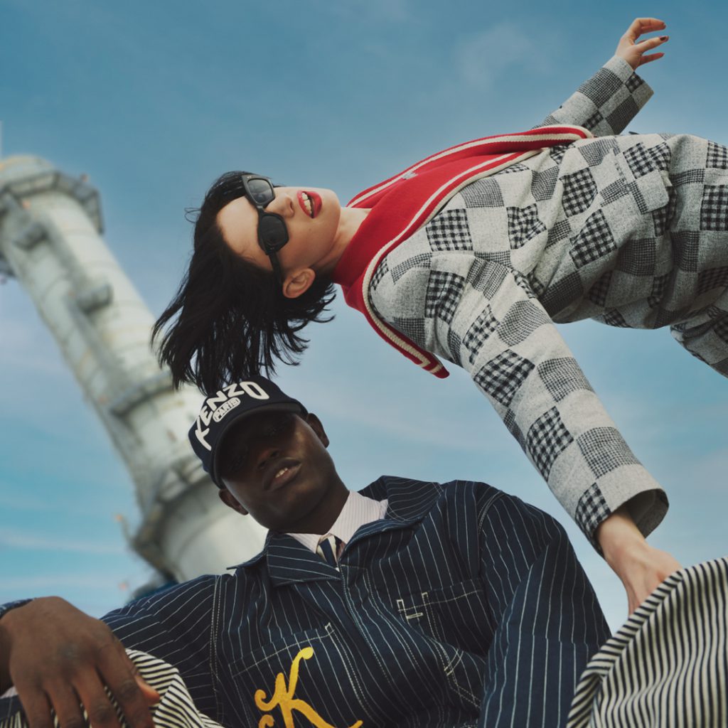 Hai người mẫu tạo dáng nghịch ngợm trên nền trời xanh với trang phục KENZO năng động