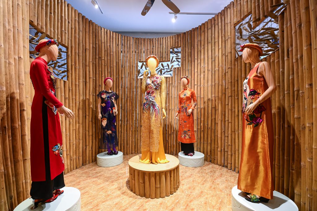 Manh hình trưng bày các thiết kế áo dài truyền thống và hiện đại trong không gian tre trúc