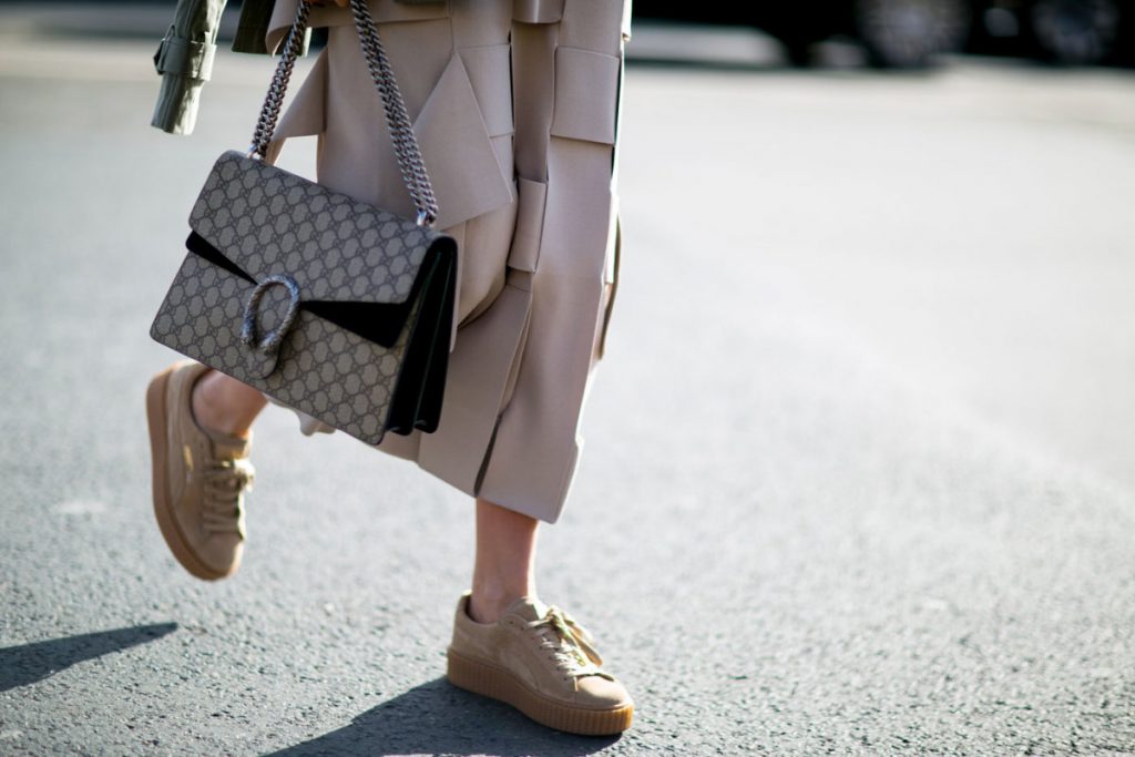 Cô gái mang giày thể thao và túi xách thời trang trên phố