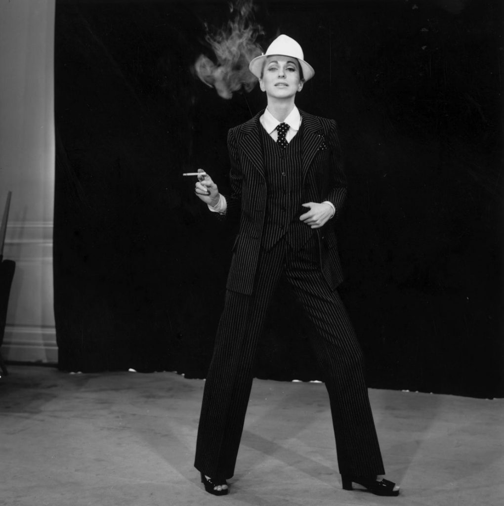 Người phụ nữ mặc vest sọc đứng tự tin tay cầm thuốc lá đang phun khói