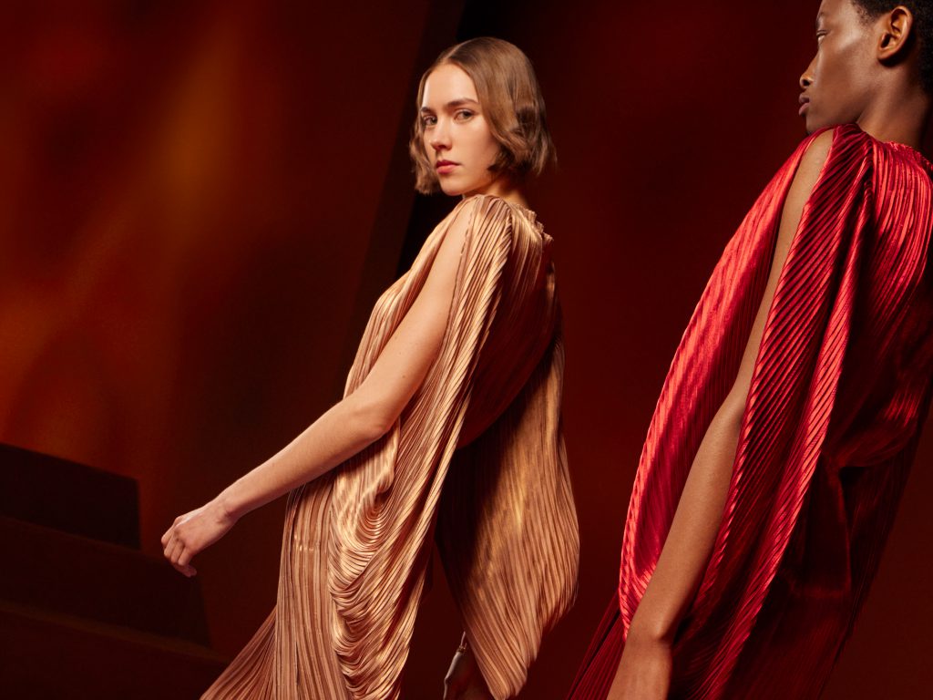 Người mẫu trình diễn trang phục xếp ly tông màu cam đỏ trong buổi giới thiệu BST Thu Đông của Hermès