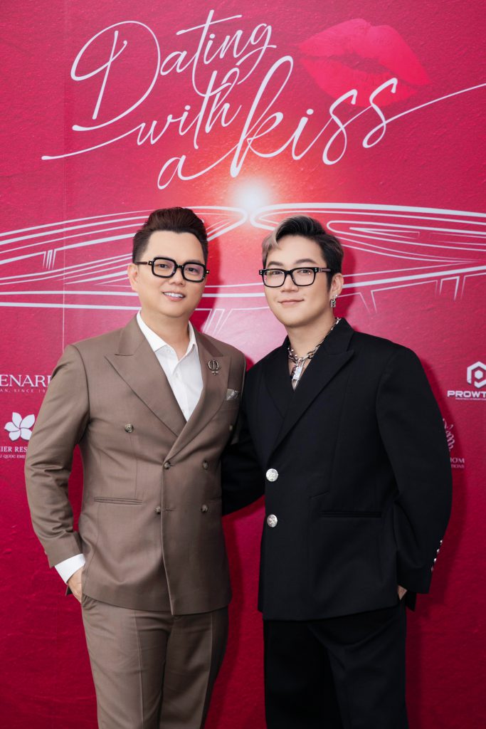 Hai nhà thiết kế thời trang lịch lãm tạo dáng trước phông nền đỏ rực rỡ