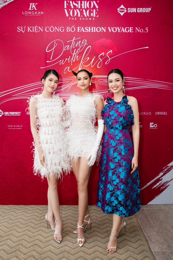 Ba người mẫu xinh đẹp tạo dáng trước phông nền đỏ tại sự kiện Fashion Voyage