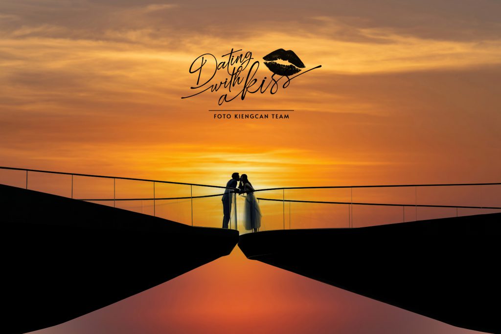 Cặp đôi trao nhau nụ hôn lãng mạn trên cầu cảng lúc hoàng hôn rực rỡ