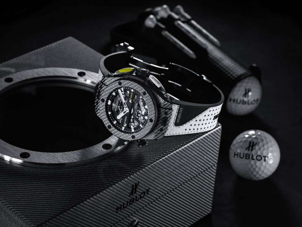 Đồng hồ Hublot Big Bang Unico Golf cùng bóng golf trên nền sợi carbon đen