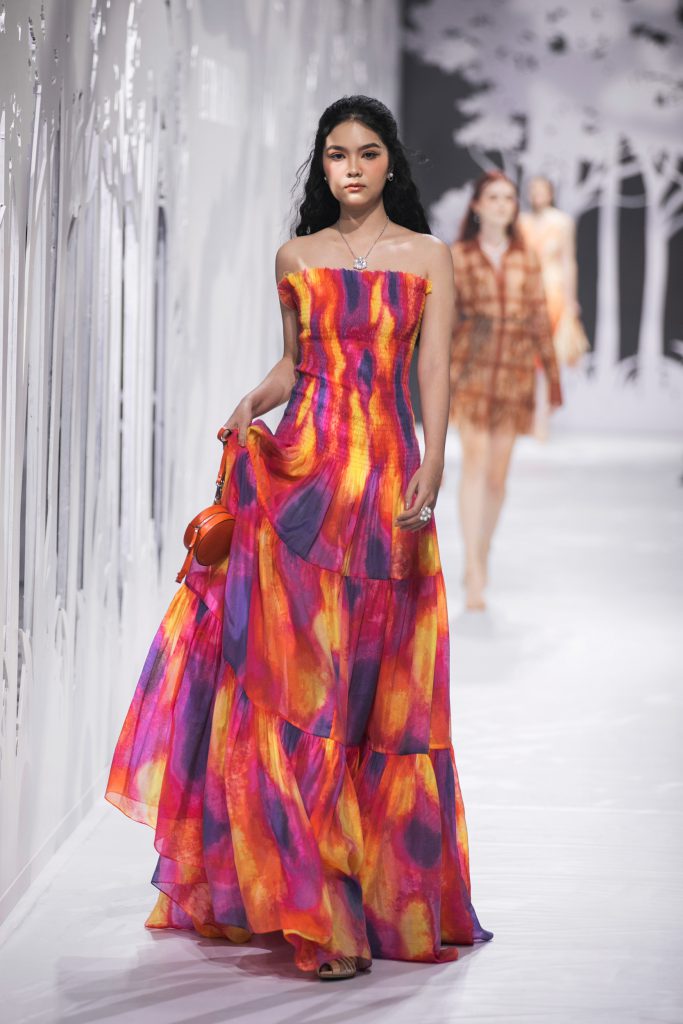 Người mẫu trình diễn váy dài họa tiết rực rỡ trên sàn catwalk