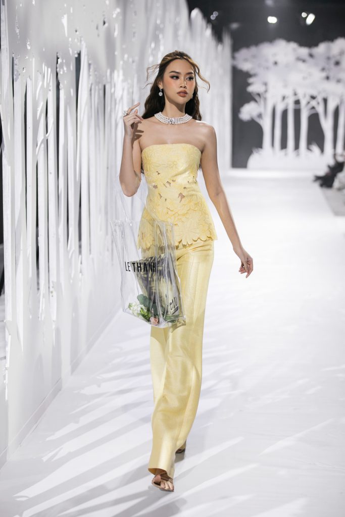 Người mẫu trình diễn trang phục vàng nhạt trên sàn diễn thời trang