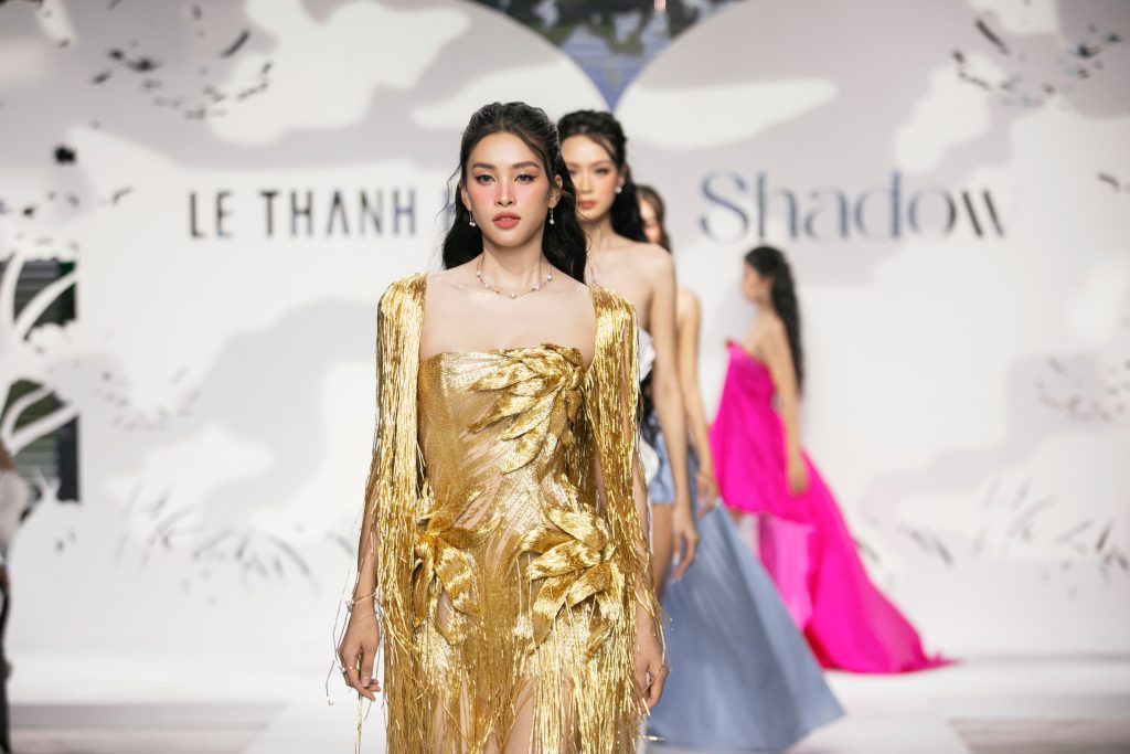 Người mẫu trình diễn váy vàng lấp lánh trên sàn catwalk trong show diễn thời trang