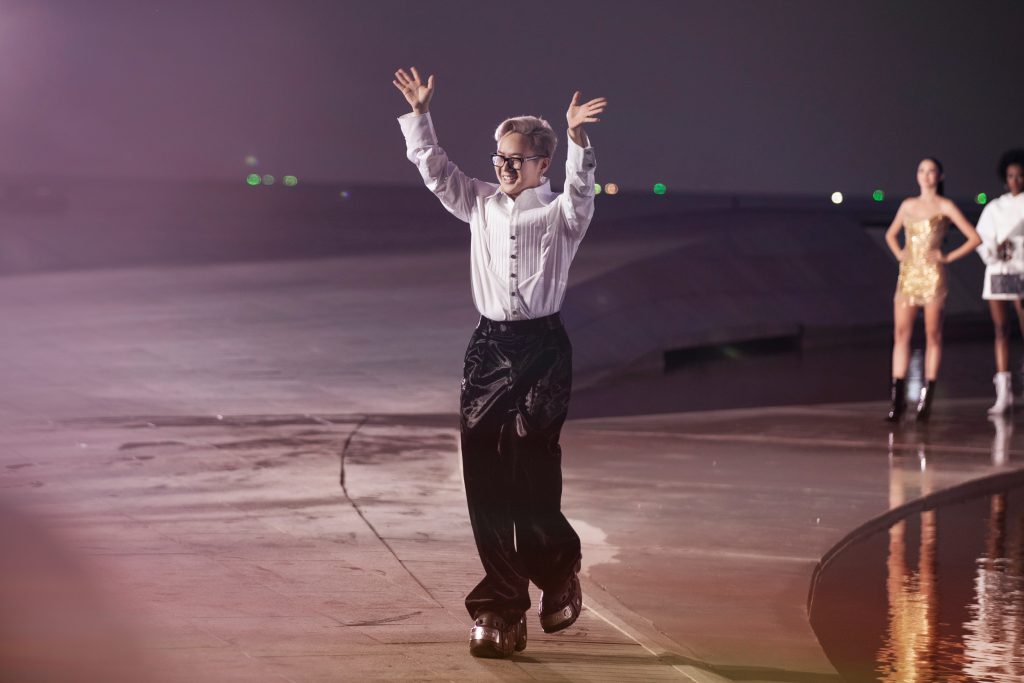 Nhà thiết kế Chung Thanh Phong vẫy tay chào khán giả trên sàn diễn thời trang