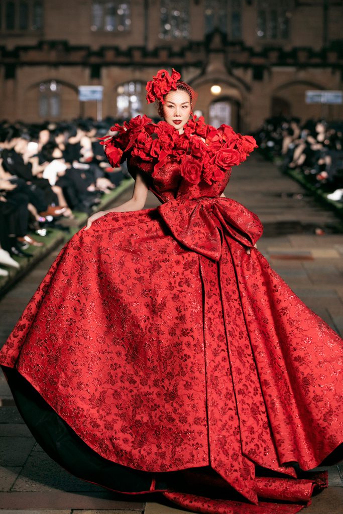 Người mẫu diện váy đỏ rực rỡ với điểm nhấn hoa hồng trên sàn diễn thời trang