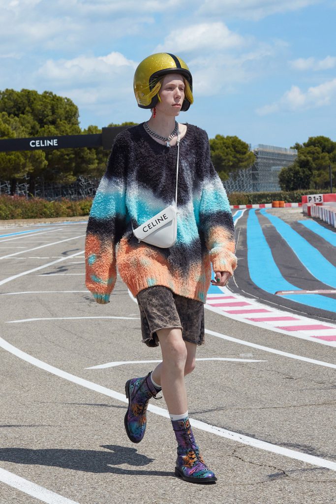 Người mẫu trẻ trung diện áo len màu sắc và mũ bảo hiểm trên đường đua