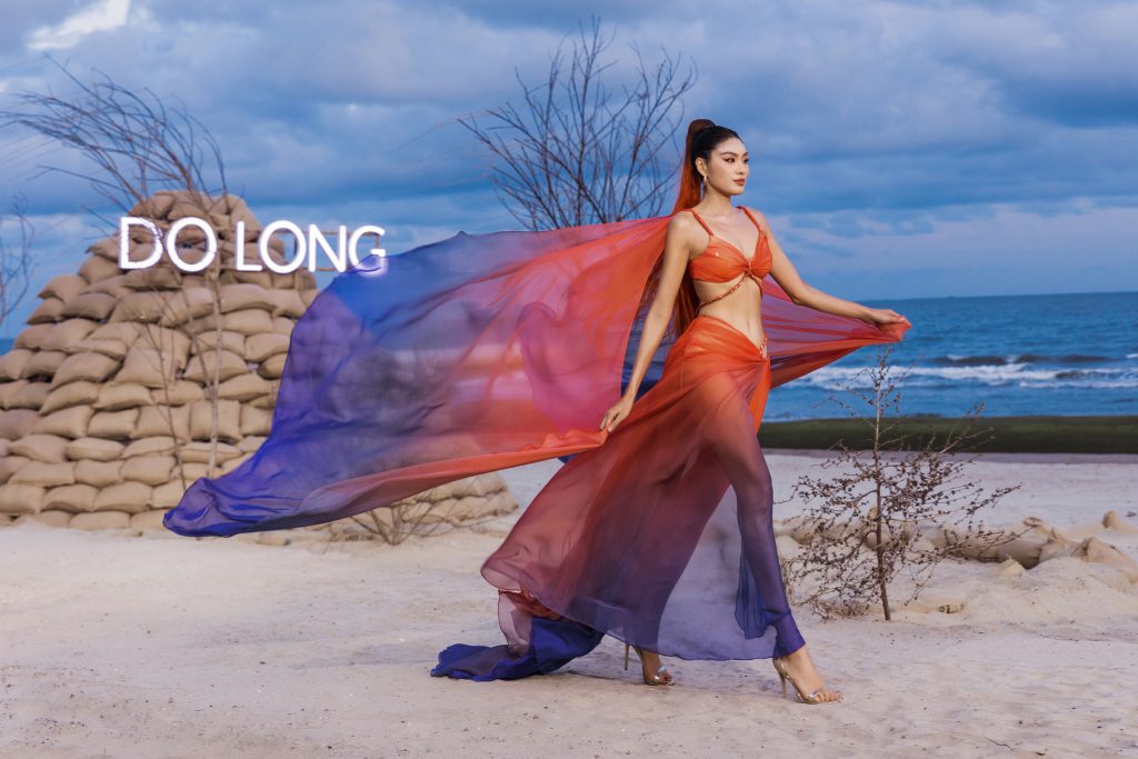 Người mẫu diện váy rực rỡ trên bãi biển cát trắng gió thổi
